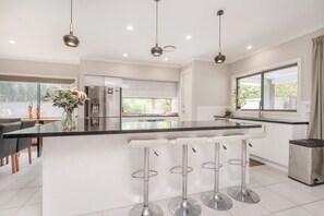 Una cocina moderna con una isla central, electrodomésticos de acero inoxidable y un amplio ventanal.