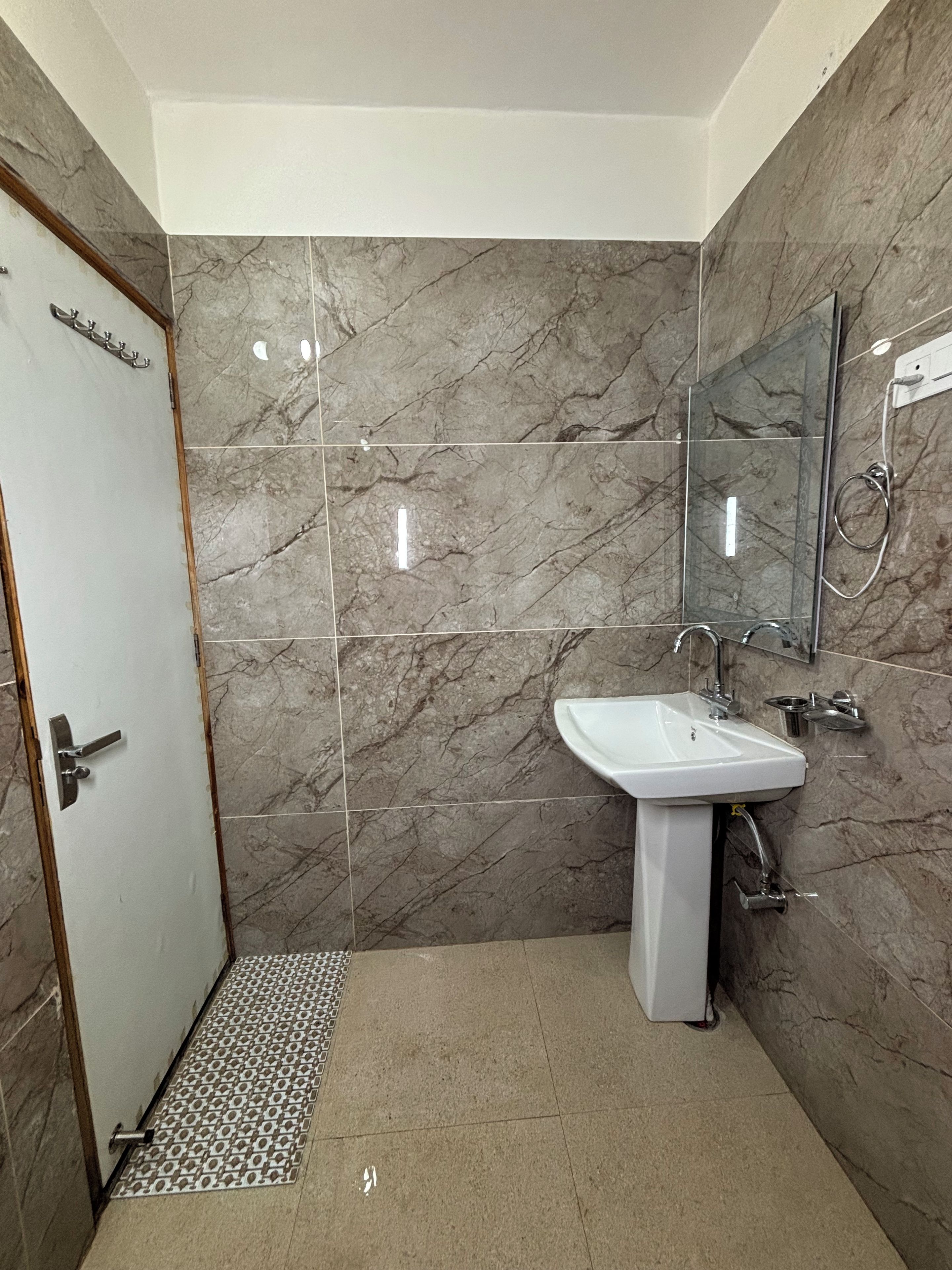 A bathroom with a white sink, a mirror, and a shower area.