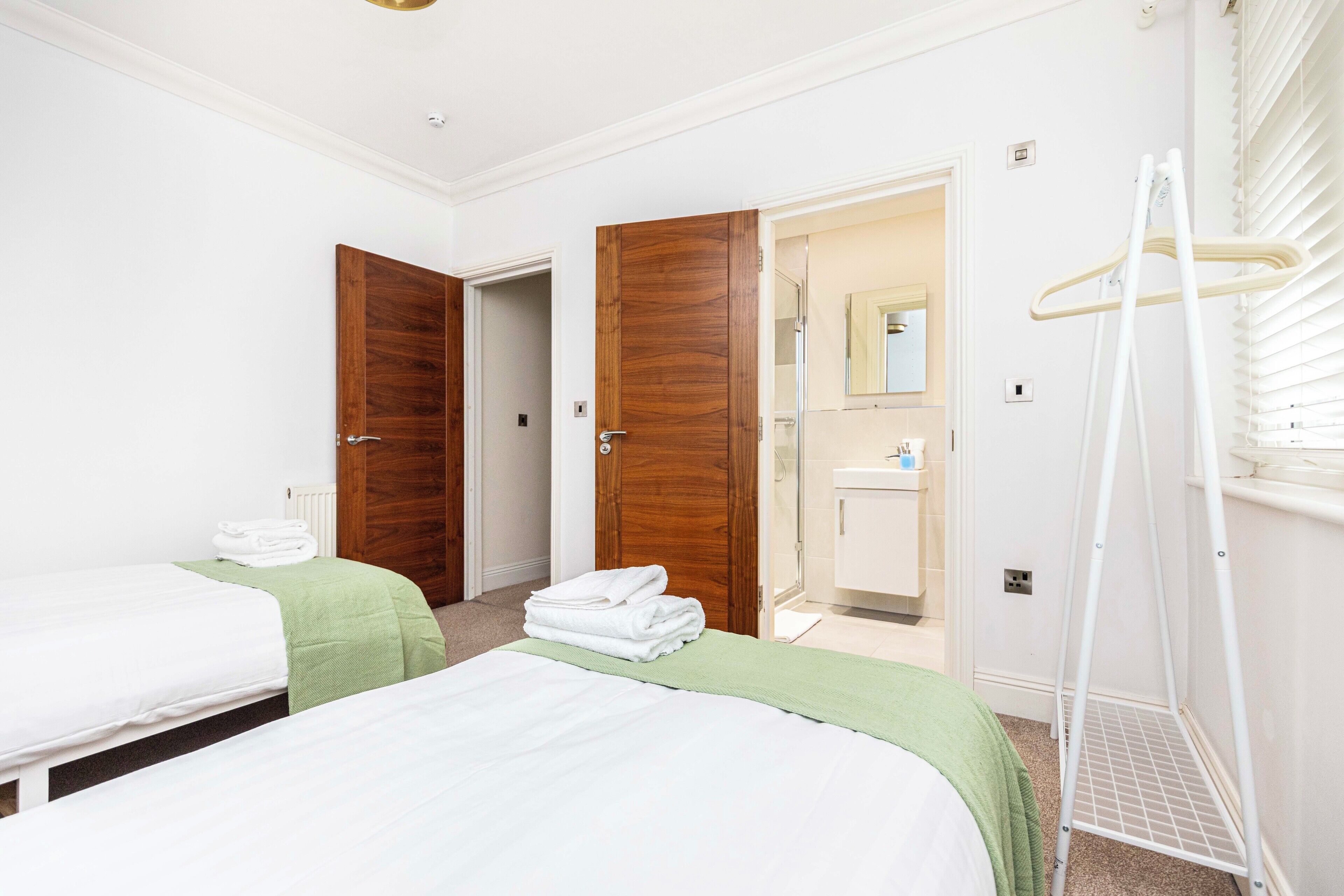 A hotel room with two beds, a bathroom, and a walk-in closet.