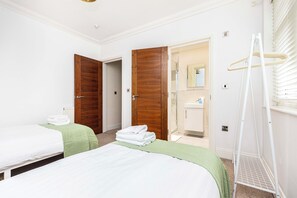 A hotel room with two beds, a bathroom, and a walk-in closet. - Spacious Talbot Woods Retreat | 2 En-Suites | Free Parking |25 min walk to Beach (Bournemouth)