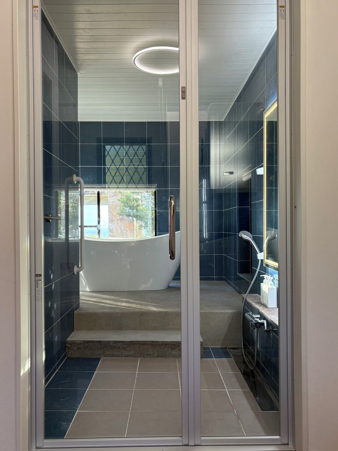 Un bagno moderno con cabina doccia in vetro, vasca e mobile lavabo con specchio.