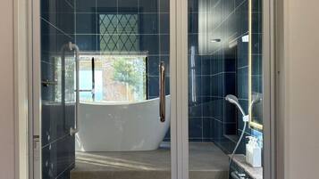 Un bagno moderno con cabina doccia in vetro, vasca e mobile lavabo con specchio.