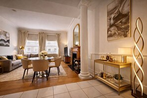Ein modernes Wohnzimmer mit Essbereich, Kamin und einer dekorativen Konsole.