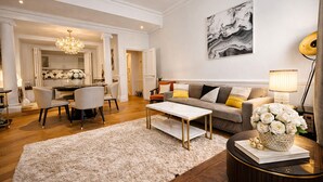 Un salon moderne comprenant un canapé, une table basse et un coin repas avec des chaises.