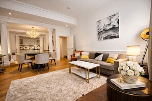 Ein modernes Wohnzimmer mit einer Couch, einem Couchtisch und einem Essbereich mit Stühlen.