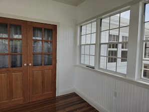 Une pièce avec une porte en bois et une grande fenêtre.