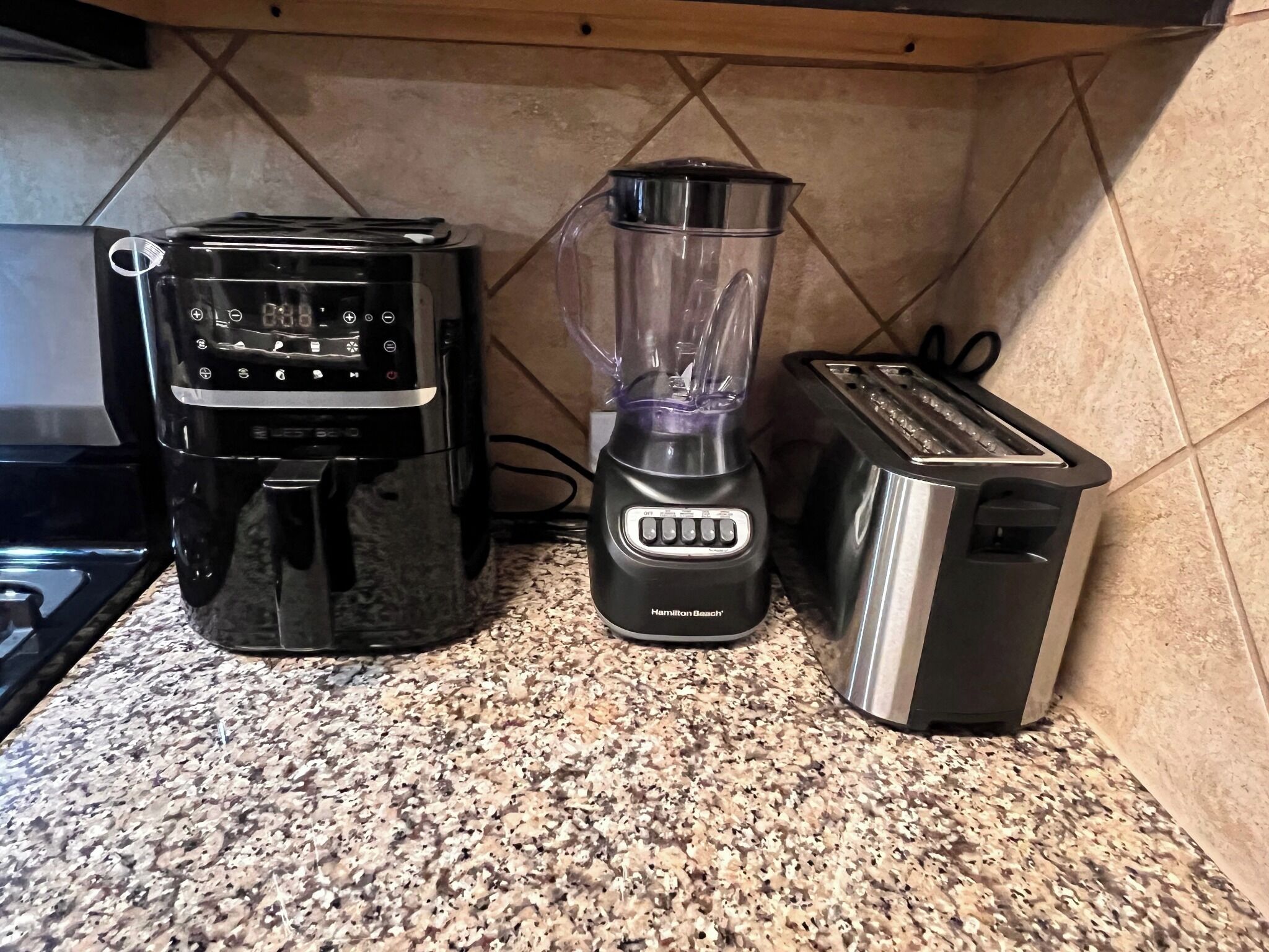 A kitchen counter with a coffee maker, a blender, and a toaster.