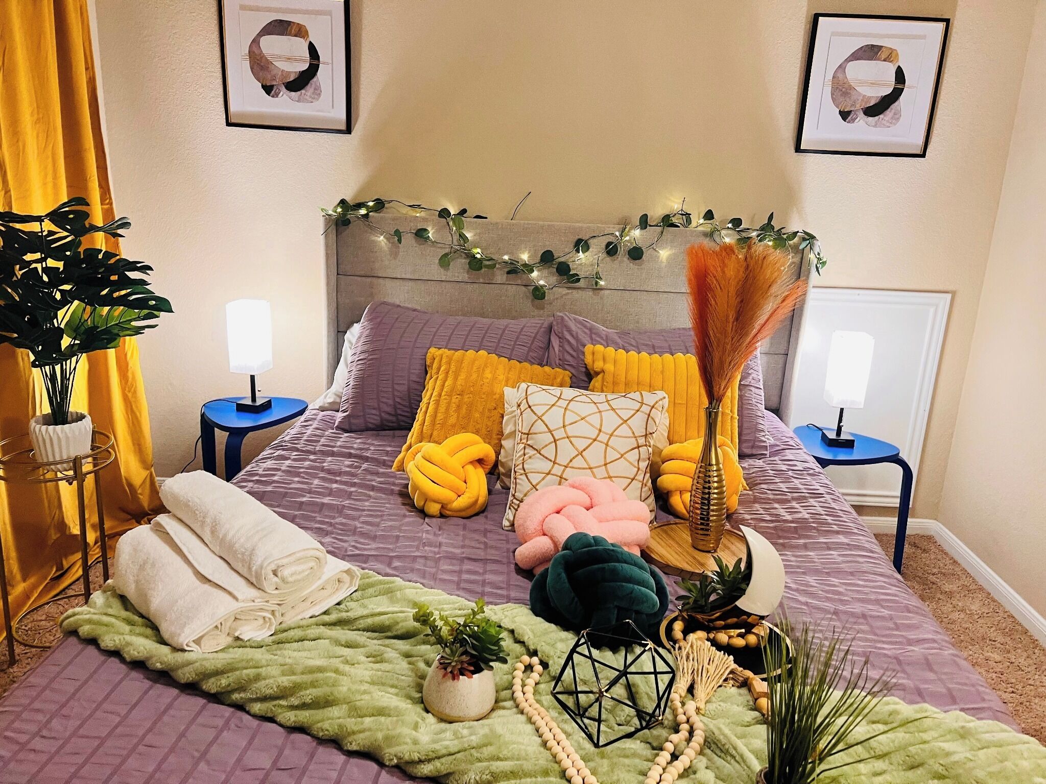Une chambre à coucher bien rangée, avec un lit, des tables de chevet, une lampe et des coussins décoratifs.