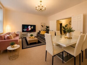 A modern living room with a television, sofa, dining table, and chairs. - Huge Westminster, 3Bed 3Bath, AC, 5 mins to St James Park, Buckingham Palace (London)