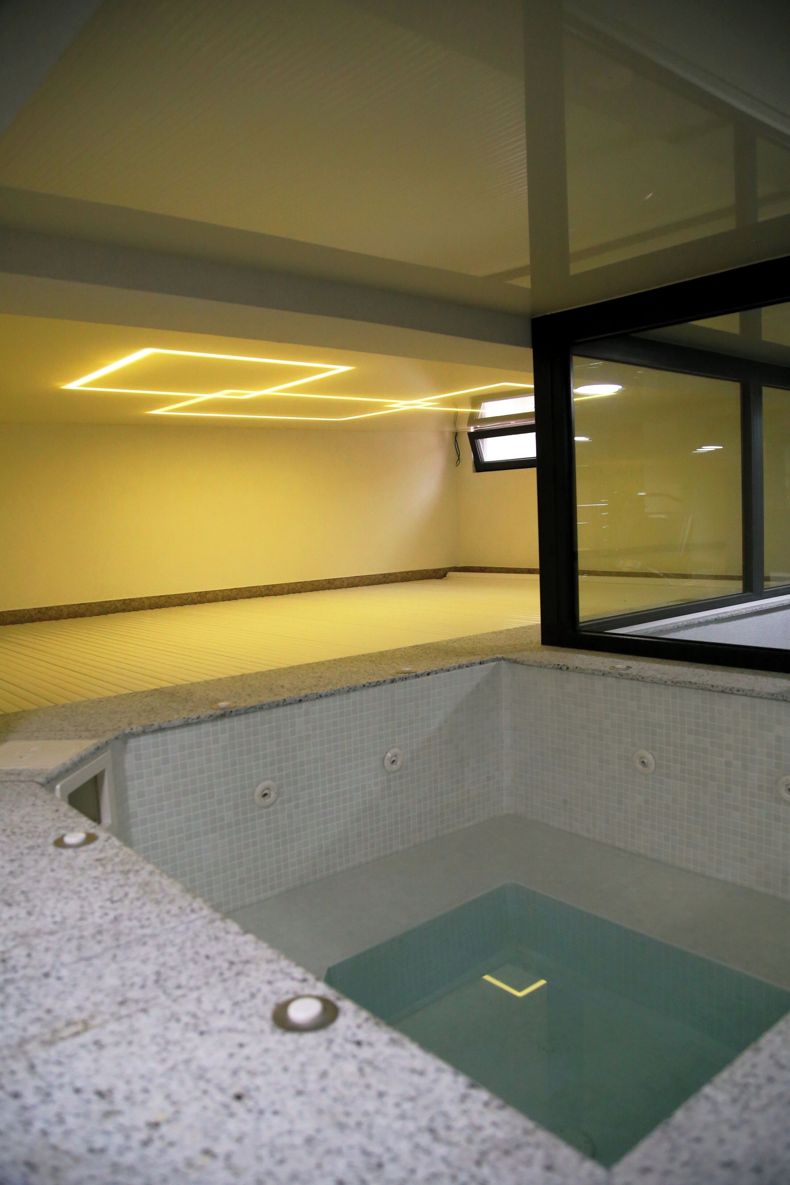 A spa room with a seating area, a window, and a tiled floor.