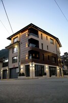 Un edificio de varios pisos con techo plano, ventanas amplias y una señal de paso de peatones.