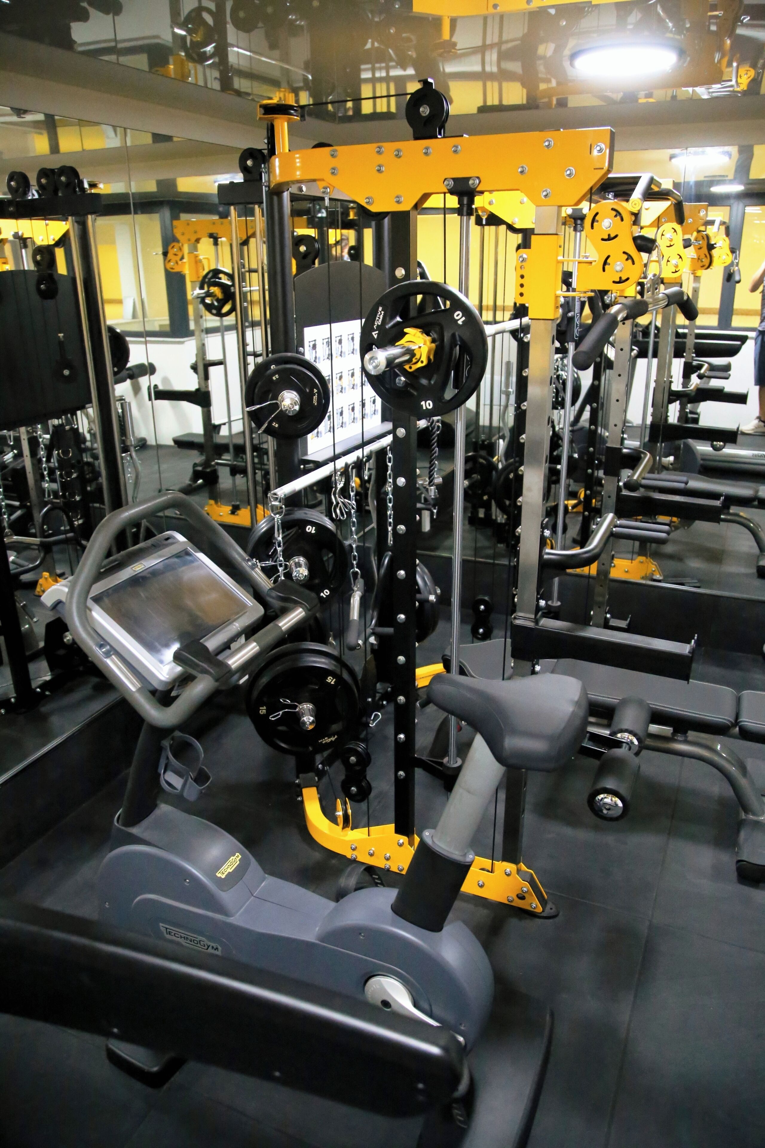 Un gimnasio con diferentes equipos de ejercicio, incluyendo cintas de correr y máquinas de pesas.