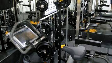 Un gimnasio con diferentes equipos de ejercicio, incluyendo cintas de correr y máquinas de pesas.
