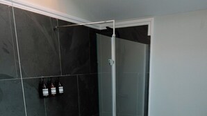 Une salle de bain moderne avec une douche, des toilettes et un lavabo.