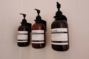 Tre flaconi di prodotti per la cura dei capelli con erogatori a pompa, ognuno indicato per un uso specifico.