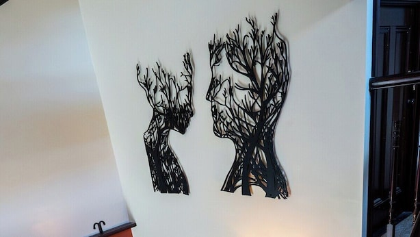 Une chambre à coucher avec un lit, une table de chevet, une commode et un escalier.