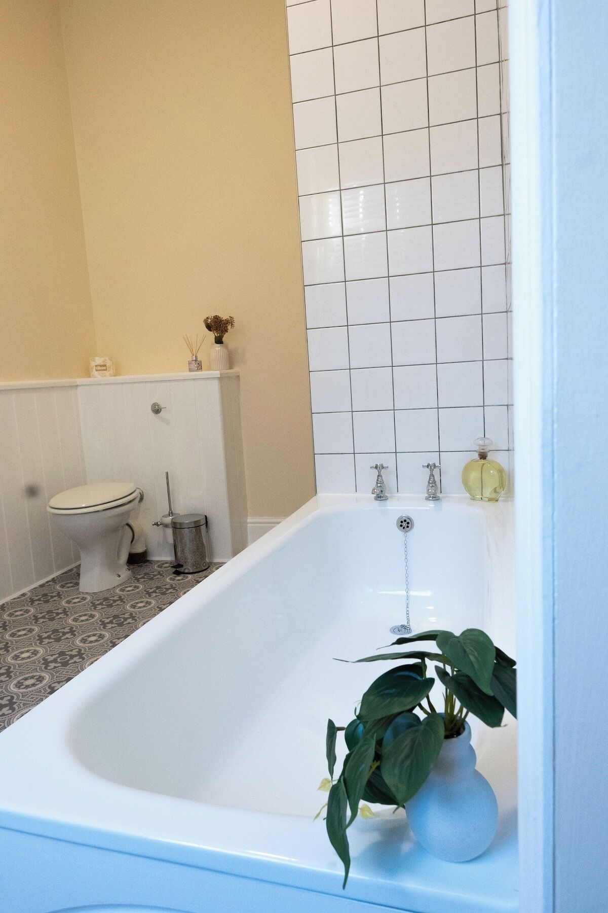 A bathroom with a white bathtub, toilet, and sink.