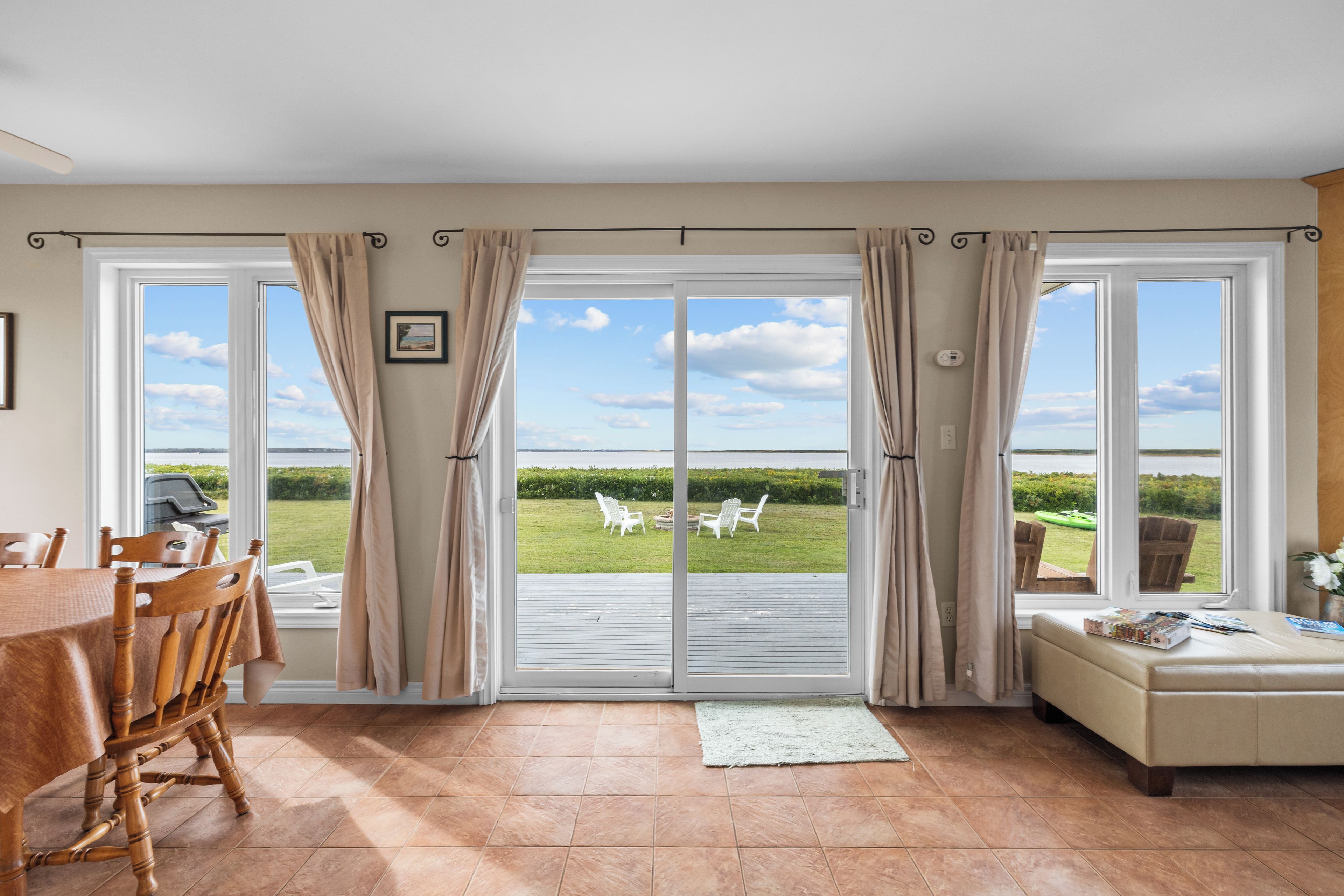 A spacious room with a large sliding glass door leading to a patio with outdoor seating.