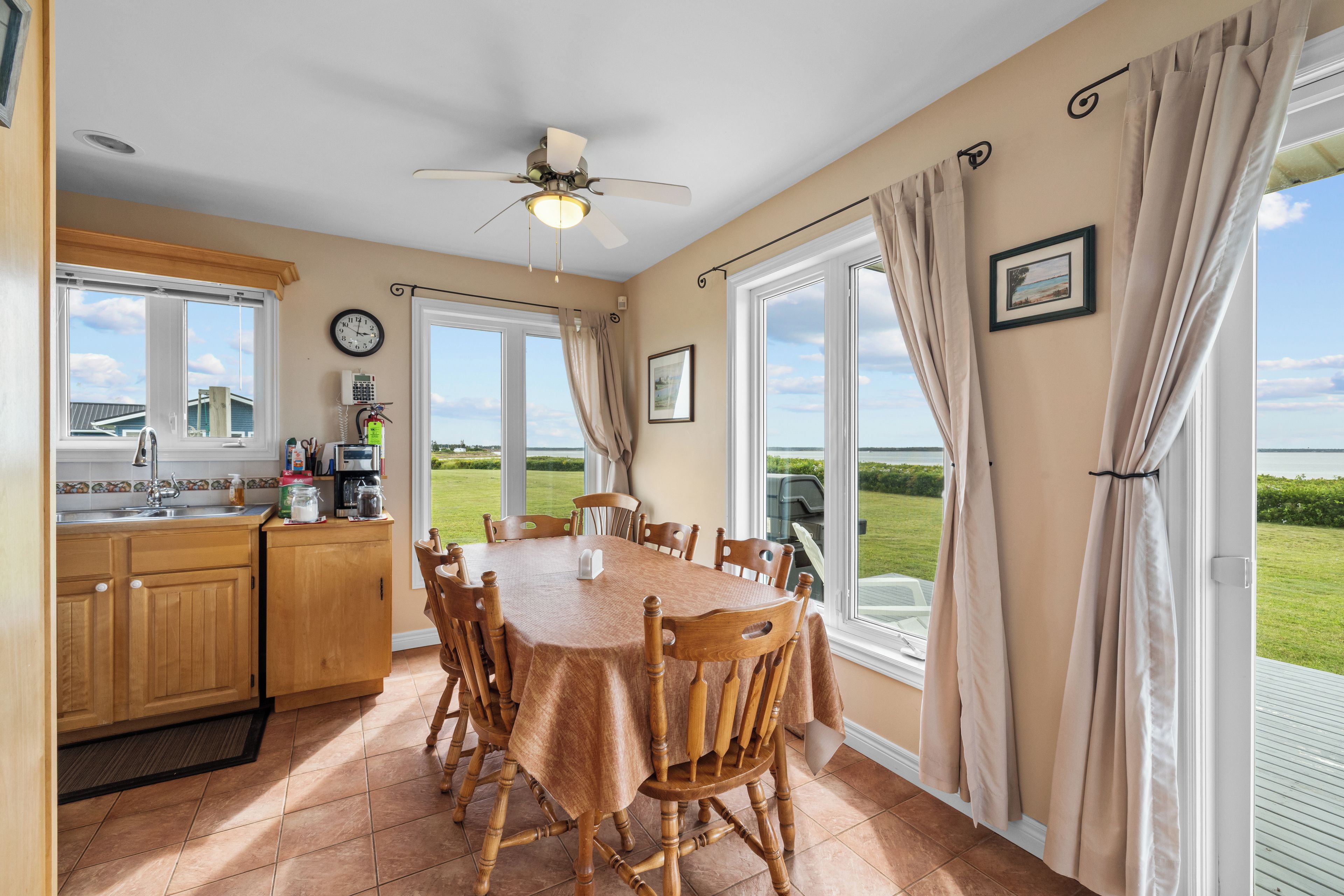 A kitchen with a dining area, large windows, and a view of the outdoors.