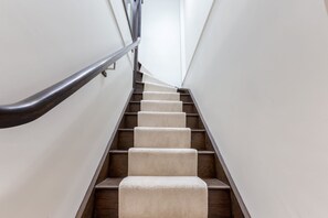 Eine Treppe mit Metallgeländer und Teppichstufen.