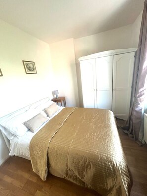 Ein Schlafzimmer mit einem Bett, einem Kleiderschrank und einem Nachttisch.