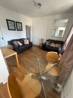 A living room with two sofas, a coffee table, and a dining table. - Stylish Central London apartment is next to the tube Chelsea border (London)