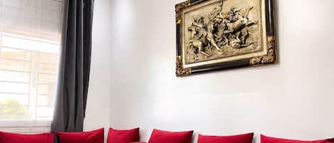 A modern living room with a sectional sofa, a glass coffee table, and a decorative wall piece.