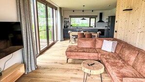 A modern living room with a large sofa, a coffee table, and a TV. - Nice apartment for 5 guests with WIFI, TV and balcony (Jilemnice)