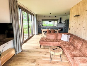 Ein modernes Wohnzimmer mit einer großen Couch, einem Couchtisch und einem Fernseher.