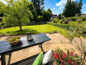 Eine Terrasse mit Tisch, Kissen und einer Obstschale.
