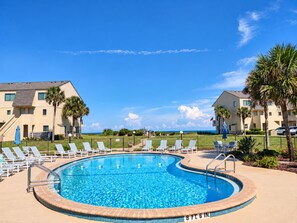 A swimming pool with lounge chairs and a view of the ocean. - Sunshine Beach Retreat at Summerhouse - Ground Floor, Heated Pools, Beach Access (St. Augustine)