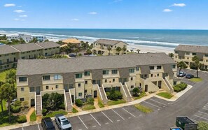 A multi-story hotel with a parking lot and a view of the beach. - Sunshine Beach Retreat at Summerhouse - Ground Floor, Heated Pools, Beach Access (St. Augustine)
