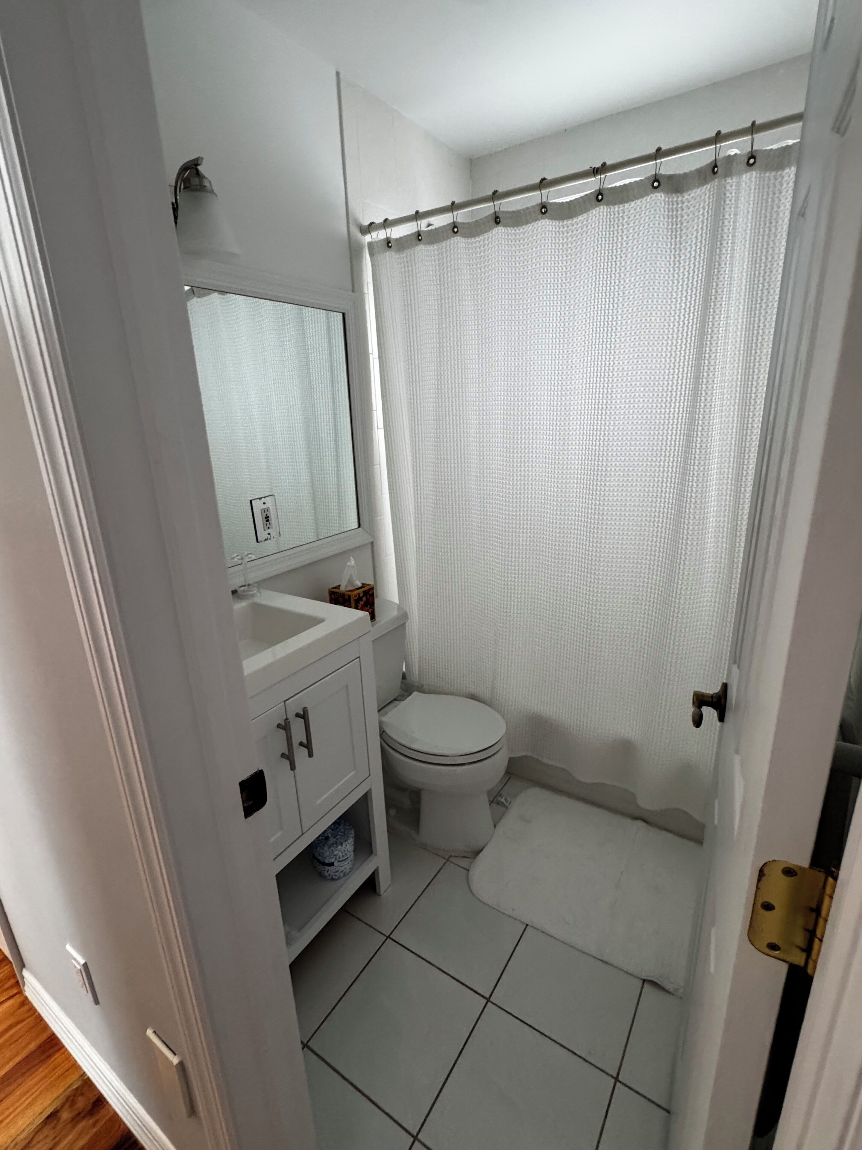 Une salle de bain avec des toilettes, un lavabo et un rideau de douche.