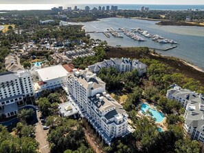 A coastal hotel with multiple buildings, a marina, and a swimming pool. - Grand Sandestin 2402 | Newly Renovated Studio | New to Program (Miramar Beach)
