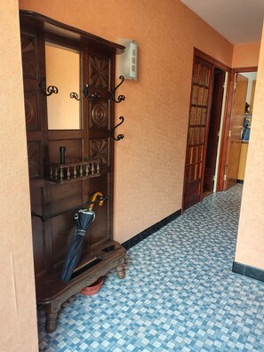 A hallway with a wooden door, a wall-mounted light switch, and a tiled floor. - 600 meters from the beach, a former farmhouse that sleeps 5; pets allowed. (Erquy)