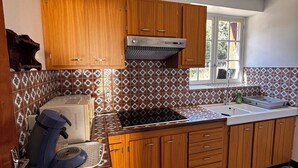 A kitchen with wooden cabinets, a built-in stove, and patterned tile backsplash.
