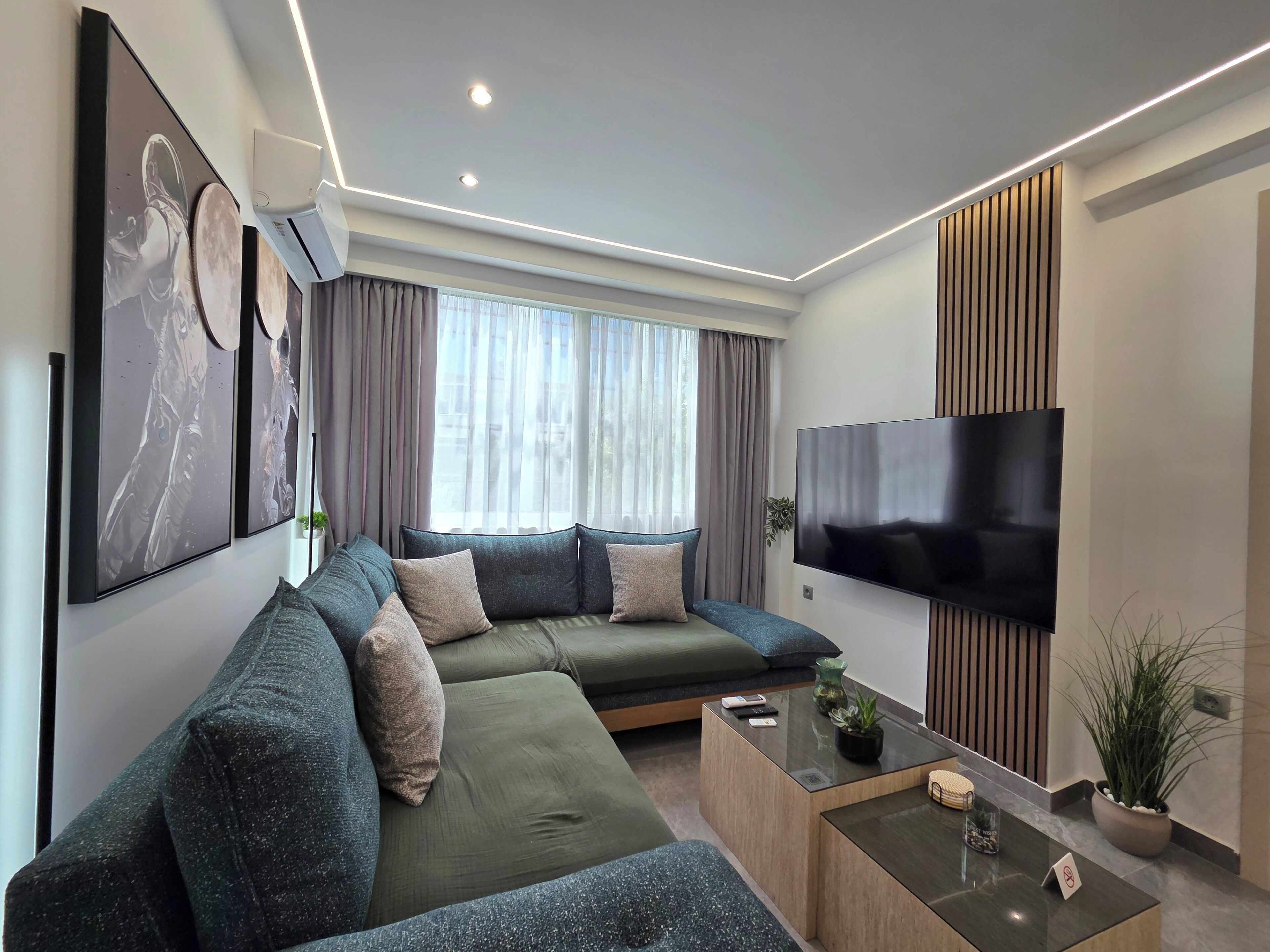A modern living room with a sectional sofa, a flat-screen TV, and a coffee table.