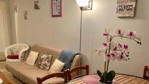 Ett vardagsrum med ett runt träbord, en soffa och en golvlampa.