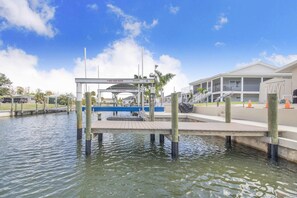 A waterfront dock with a covered walkway, a marina, and a building with a balcony. - Ga1970 3 Bedroom Home (Englewood)