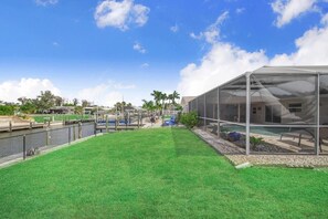A residential property with a swimming pool, a covered outdoor area, and a well-maintained lawn. - Ga1970 3 Bedroom Home (Englewood)