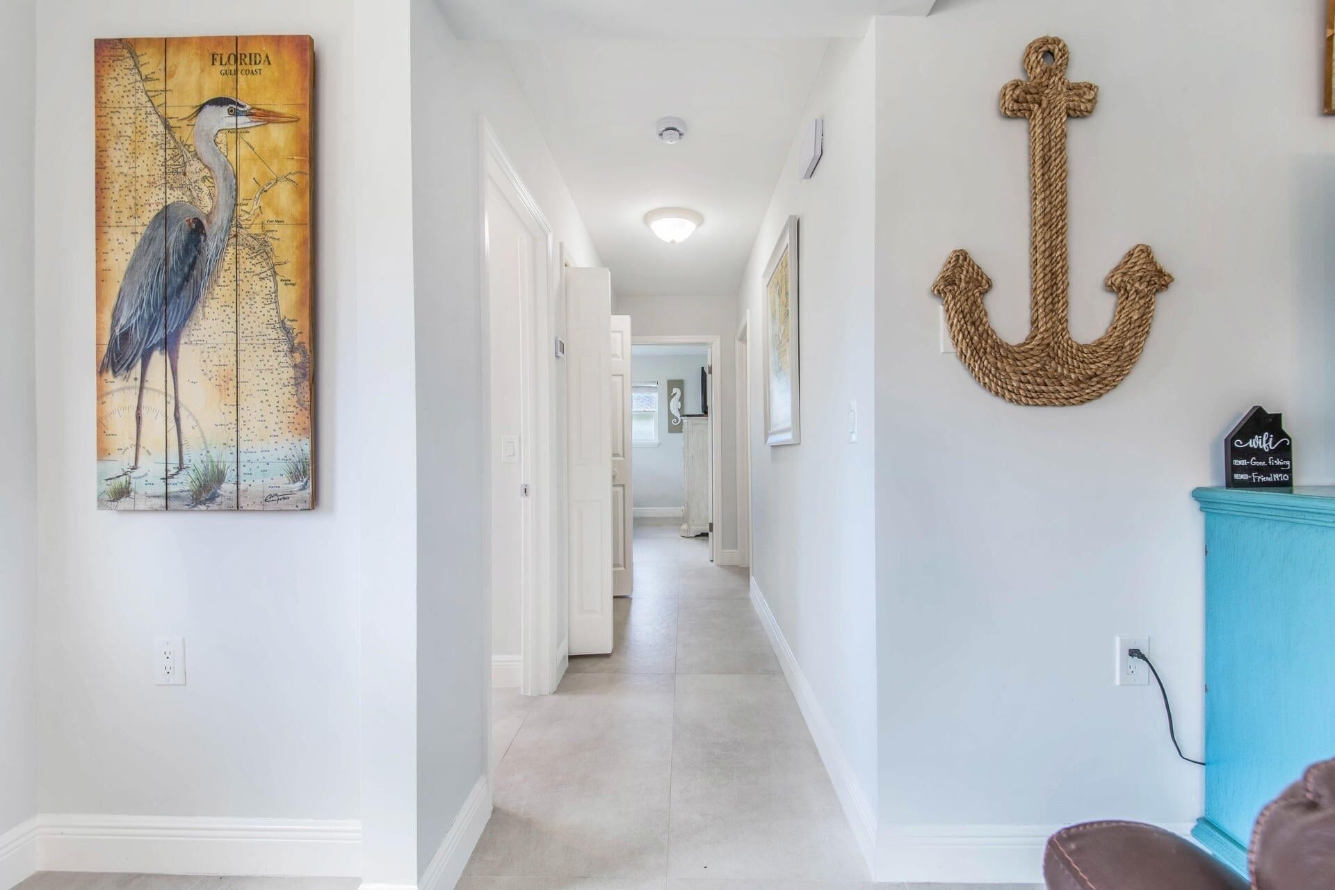 Un corridoio con una mappa della costa del Golfo della Florida, una decorazione a forma di ancora di legno e un armadietto blu.