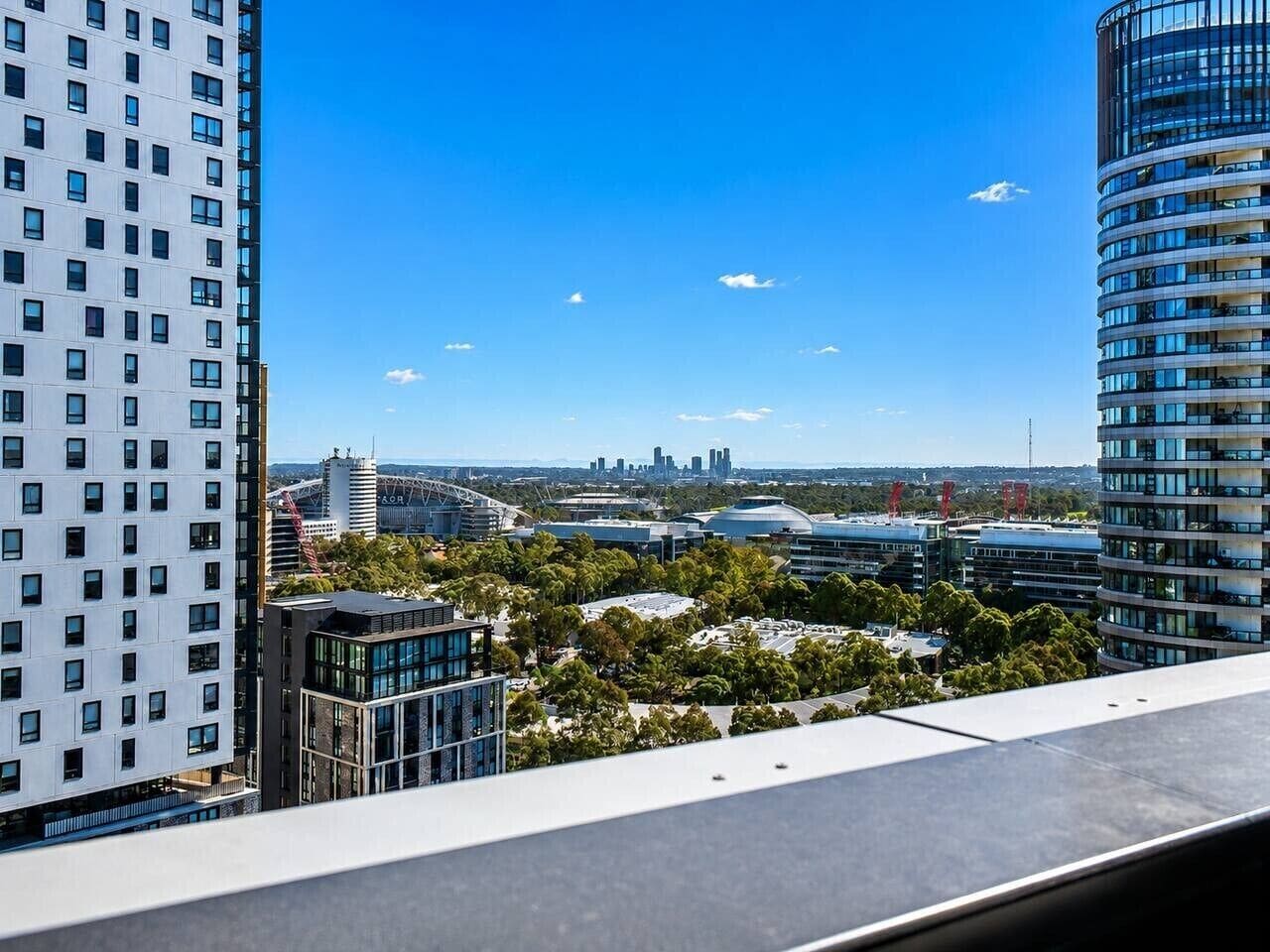 A high-rise building with a view of a cityscape, including other buildings and a clear sky.
