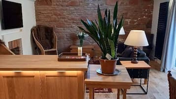 A cozy loft-style living space with a wooden bench, a potted plant, and a hanging light fixture.