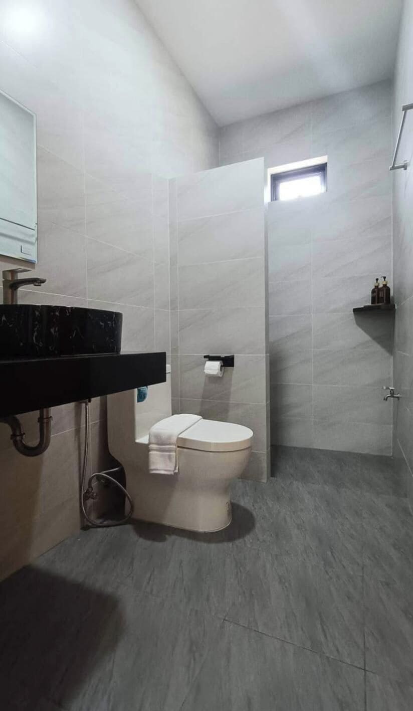 A modern bathroom with a toilet, a sink, and a shower area.