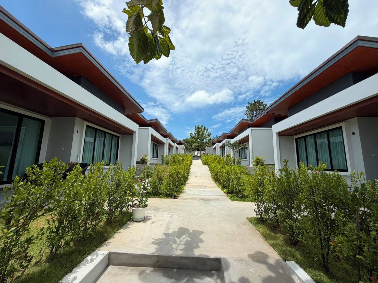 A row of modern, single-story buildings with large windows and a central pathway.
