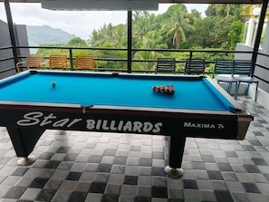 A Star Billiards pool table with a view of lush greenery and mountains in the background. - Avana Hills Tagaytay Manor - London (Tagaytay)