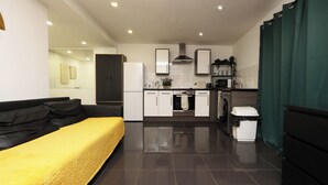 A modern kitchen with white cabinets, a black countertop, and a stainless steel range hood. - Walk to Stadium and City Center (Cardiff)