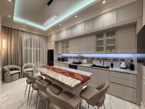 A modern kitchen with a marble countertop, bar stools, and a chandelier. - Stylish stay in a heart of Yerevan between Republic Square and Opera (Yerevan)