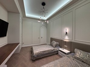 A bedroom with a bed, bedside table, and a TV mounted on the wall. - Stylish stay in a heart of Yerevan between Republic Square and Opera (Yerevan)