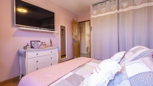 A bedroom with a bed, dresser, mirror, and a television on the wall. - Spacieux Appartement L Instant Mediterranee (Cers)